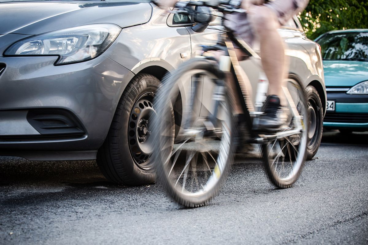 Fahrradfahrer fährt an Auto vorbei